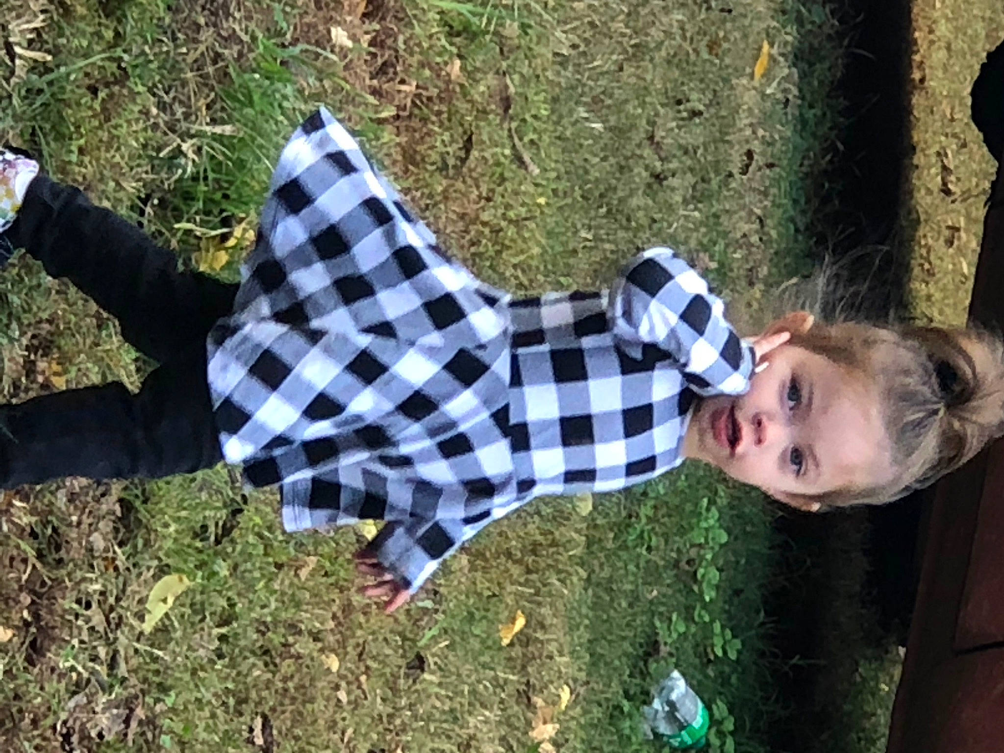 Delilah joined the competition — help win amazing prizes! fun, grass, grass_family, happy, human_leg, leisure, pattern, people_in_nature, person, plaid, plant, recreation, shadow, sitting, soil, sunlight, tartan, toddler, tree, wood