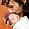 Paisley is registered to the contest to win money with this photo: baby, newborn, man, kiss, affection, love, sleeping, headband, bow, wrapped, blanket, portrait, closeup, family, tender, indoor, warm, gentle, care, beard