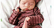 Paisley is registered to the contest to win money with this photo: baby, sleeping, infant, hand, finger, headband, striped_clothing, pink, soft, white_background, peaceful, cute, newborn, resting, child, person, portrait, cozy, indoors, toddler