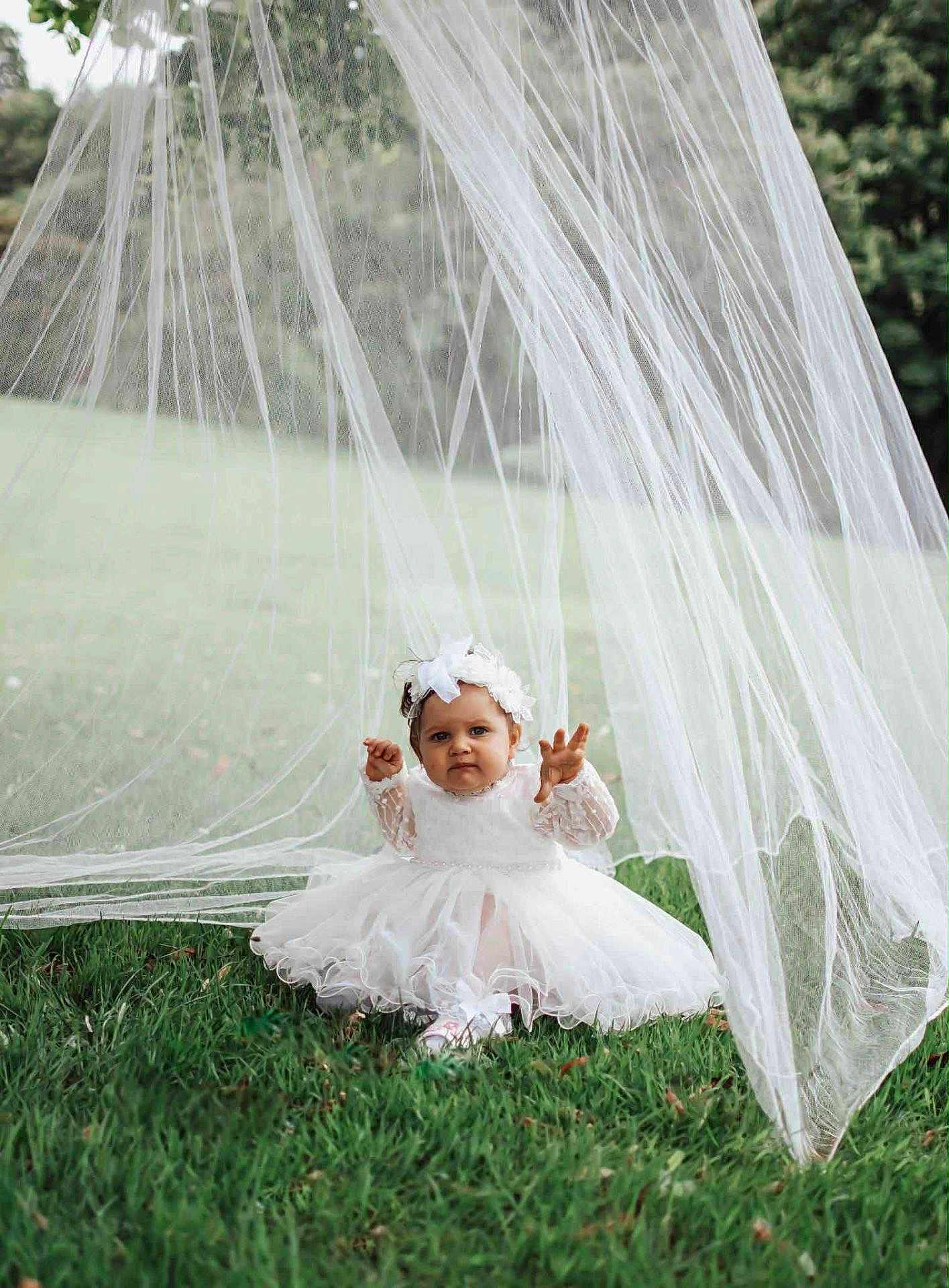 Milena is registered to the contest to win money with this photo: toddler, child, white_dress, headband, grass, outdoor, nature, tulle, fabric, greenery, cute, sitting, playful, portrait, baby, dress, flower_headband, young_child, garden, innocence