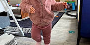 Milena joined the competition — help win amazing prizes! toddler, child, pink_hat, pink_jacket, pink_pants, pink_shoes, indoor, living_room, toy_car, television, wooden_floor, rug, furniture, baby, person, walking, cute, warm_clothing, home, floor