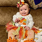 Lyra joined the competition — help win amazing prizes! baby, child, smile, couch, tutu, headband, bow, striped_leggings, orange, white, fall, autumn, cute, happy, toddler, sitting, blanket, plush, person, indoor
