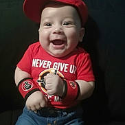 Zachariah is registered to the contest to win money with this photo: apparel, baby, child, clothing, cute, denim_shorts, face, happy, indoor, infant, motivation, person, portrait, positive_message, red_cap, red_shirt, sitting, smiling, wristbands, young_child