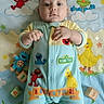 Zachariah is registered to the contest to win money with this photo: baby, infant, sesame_street, onesie, blanket, blocks, elmo, cookie_monster, big_bird, oscar_the_grouch, child, cute, smiling, lying_down, colorful, playful, toy, pattern, soft, indoors