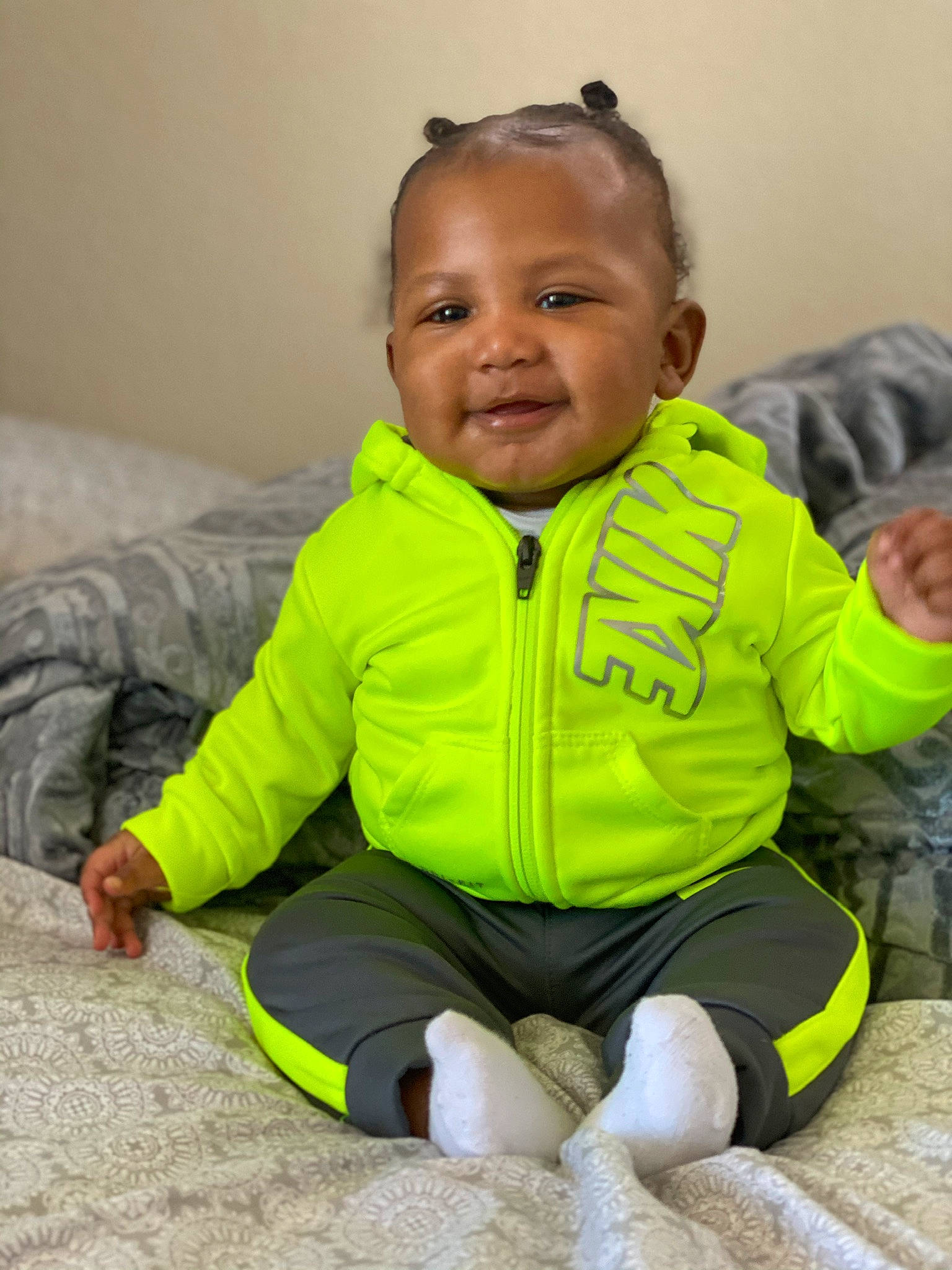Aryan is registered to the contest to win money with this photo: baby, cheek, child, face, green, head, hoodie, jacket, nose, outerwear, person, play, sitting, skin, sleeve, smile, standing, toddler, yellow