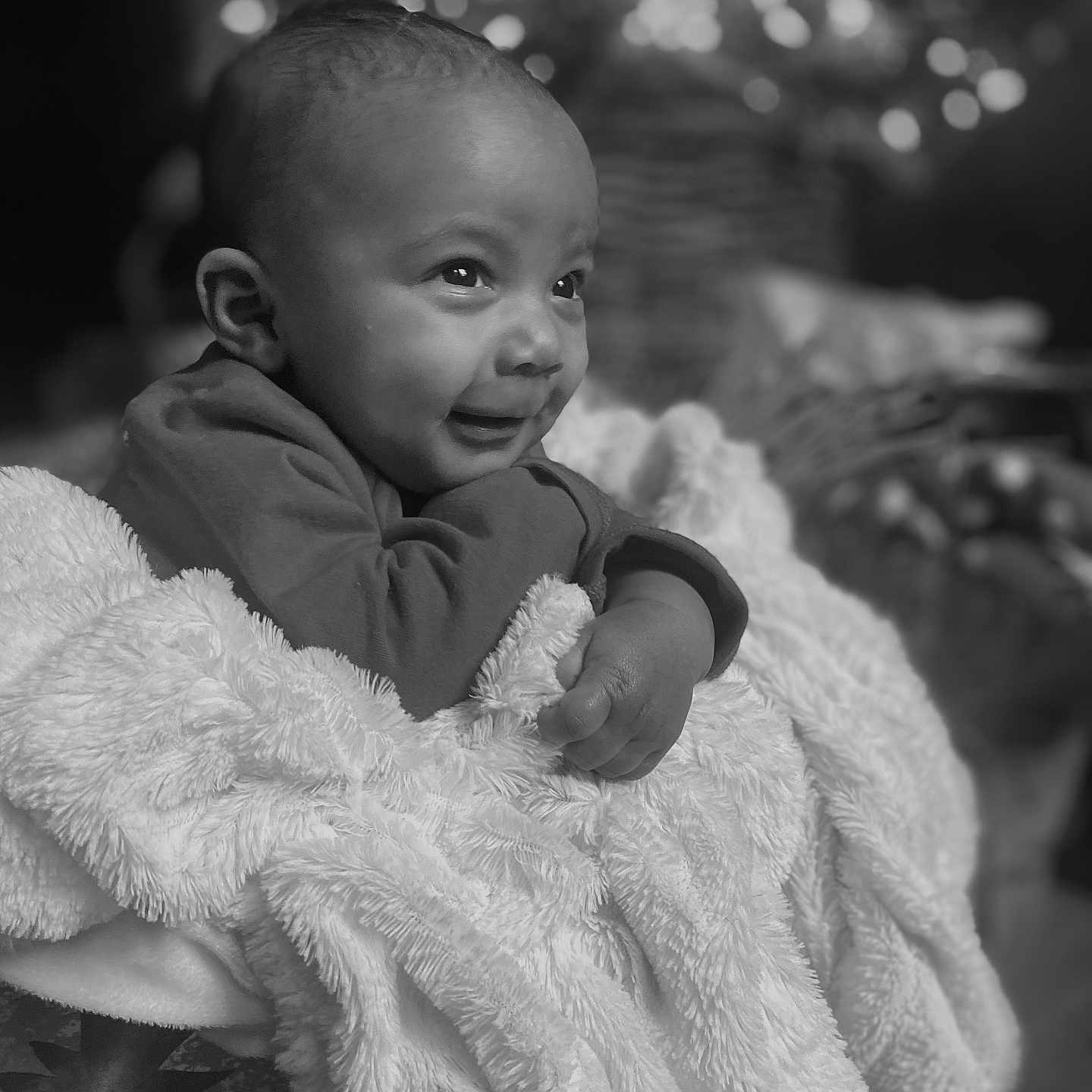 Micah joined the competition — help win amazing prizes! baby, black_and_white, blanket, child, closeup, cozy, curly_hair, cute, expression, face, focus, hand, happy, indoor, infant, portrait, smiling, soft_texture, warm, wrap