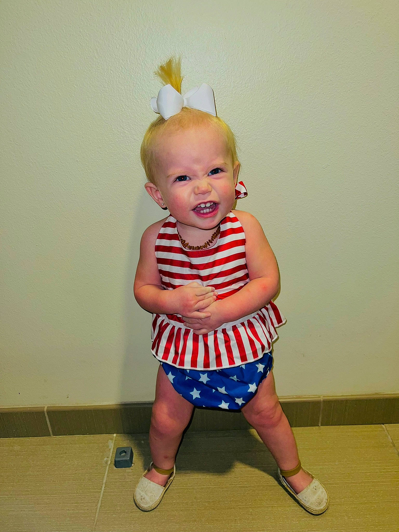 Emmi is registered to the contest to win money with this photo: baby, baby_toddler_clothing, child, day_dress, electric_blue, eye, face, flooring, foot, fun, happy, head, human_leg, knee, pattern, person, sandal, sleeve, smile, t_shirt