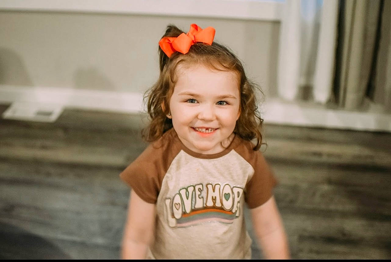 Shiley is registered to the contest to win money with this photo: blond, brown_hair, child, dress, eye, face, fashion_accessory, flash_photography, flooring, fun, happy, iris, joy, laugh, lip, neck, person, portrait_photography, recreation, smile