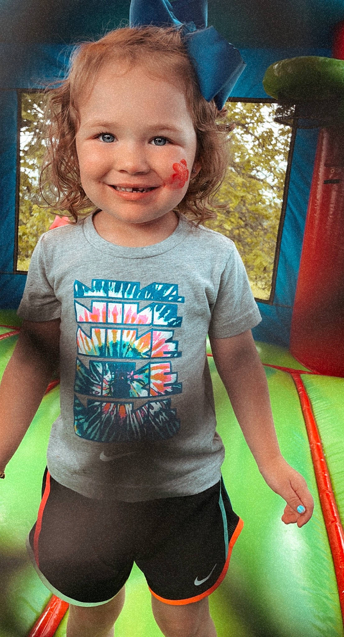 Shiley is registered to the contest to win money with this photo: blue, chin, cool, eye, facial_expression, hairstyle, happy, human, joy, mammal, neck, organ, person, plant, shoulder, sleeve, smile, standing, toddler, tree