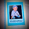 baby, child, infant, portrait, smiling, happy, sitting, blue_hat, onesie, stars, socks, printed_photo, keepsake, scrapbook, book, paper, blue_frame, indoor, closeup, family_memento