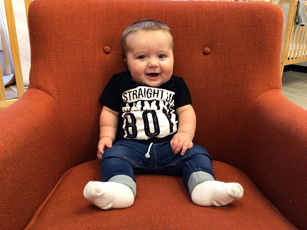 Brock is registered to the contest to win money with this photo: baby, baby_toddler_clothing, cheek, chin, comfort, couch, eye, face, floor, flooring, fun, head, joy, knee, person, skin, sleeve, smile, t_shirt, thigh