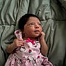 baby, infant, child, pink_dress, hello_kitty, blanket, bed, cute, portrait, lying_down, hand, face, expression, clothing, sleepwear, newborn, indoor, soft, adorable, resting