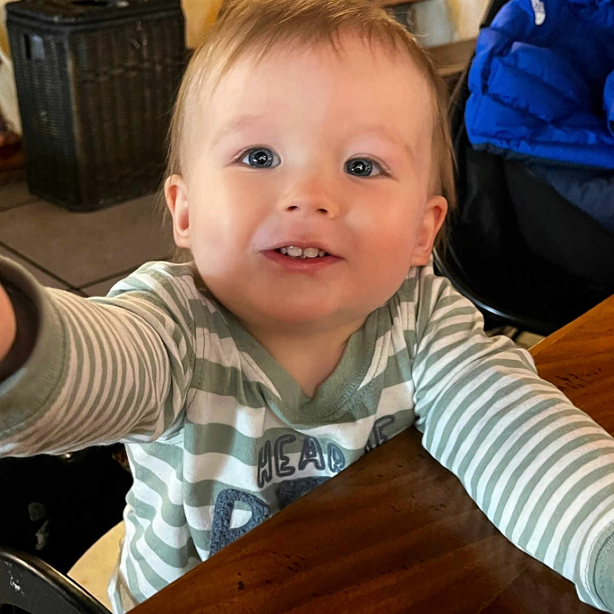 Quinlen is registered to the contest to win money with this photo: baby, blonde, bodypart, clothing, face, finger, furniture, hair, hand, happy, hardwood, head, indoors, person, photography, portrait, sitting, smile, t_shirt, wood