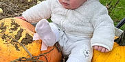 Ruby joined the competition — help win amazing prizes! baby, child, pumpkin, outdoor, fall, hat, white_clothing, grass, field, cloudy_sky, cute, person, seasonal, nature, autumn, portrait, sitting, pom_pom_hat, soft_texture, hand