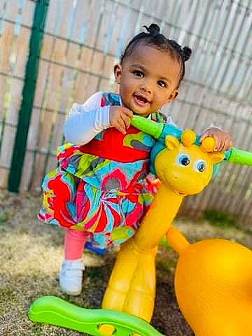 Maïlyna participe au concours pour gagner de l'argent avec cette photo : baby, baby_products, baby_toddler_clothing, baby_toys, child, dress, fun, grass, happy, lawn_ornament, leisure, mammal, person, pink, plant, recreation, smile, toddler, toy, vertebrate