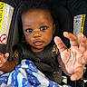 baby, child, car_seat, blanket, hand, face, curly_hair, seatbelt, clothing, indoor, infant, expression, cute, person, portrait, young, sitting, blue, black_hair, looking