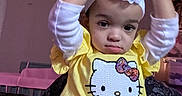 Zaniyah-Ann joined the competition — help win amazing prizes! toddler, child, headband, flower, yellow_shirt, hello_kitty, patterned_pants, indoor, serious_expression, person, sitting, clothing, cute, young_child, portrait, baby, face, head, long_sleeve, casual