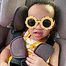 toddler, child, car_seat, sunglasses, yellow, floral_dress, harness, seatbelt, cute, baby, smiling, indoors, safety, car, seat, person, portrait, fashion, accessory, playful