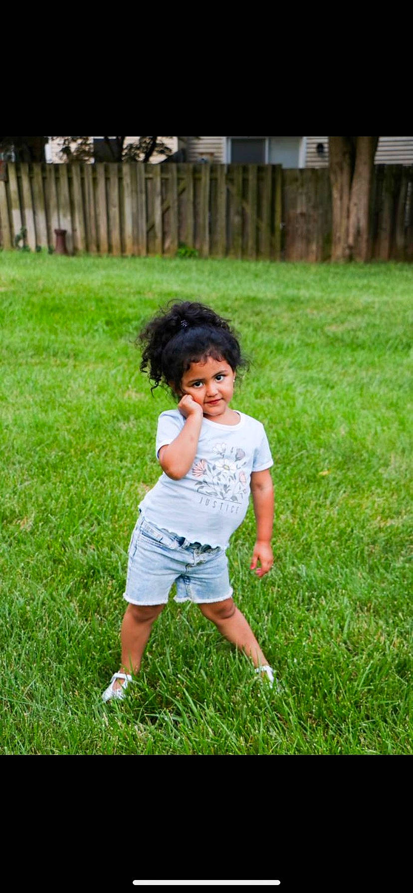 Mariana is registered to the contest to win money with this photo: baby_toddler_clothing, child, face, fence, fun, garden, grass, grass_family, grassland, hair, happy, lawn, leaf, leisure, people_in_nature, person, recreation, shorts, summer, t_shirt