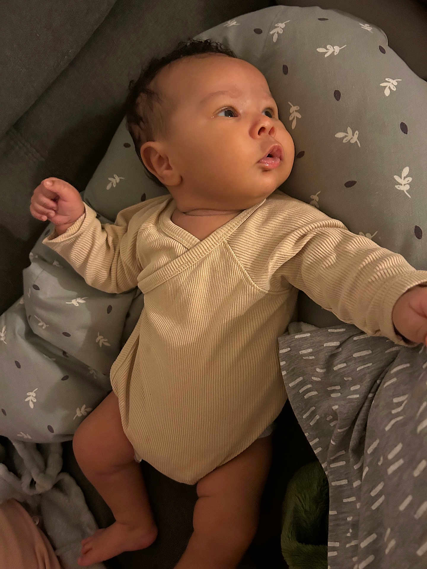 Keywen a rejoint le concours — aidez-le/la à gagner de superbes lots ! baby, infant, onesie, cushion, gray, pattern, soft_lighting, skin, face, hand, foot, person, indoor, clothing, cute, child, newborn, lying_down, curious, cozy