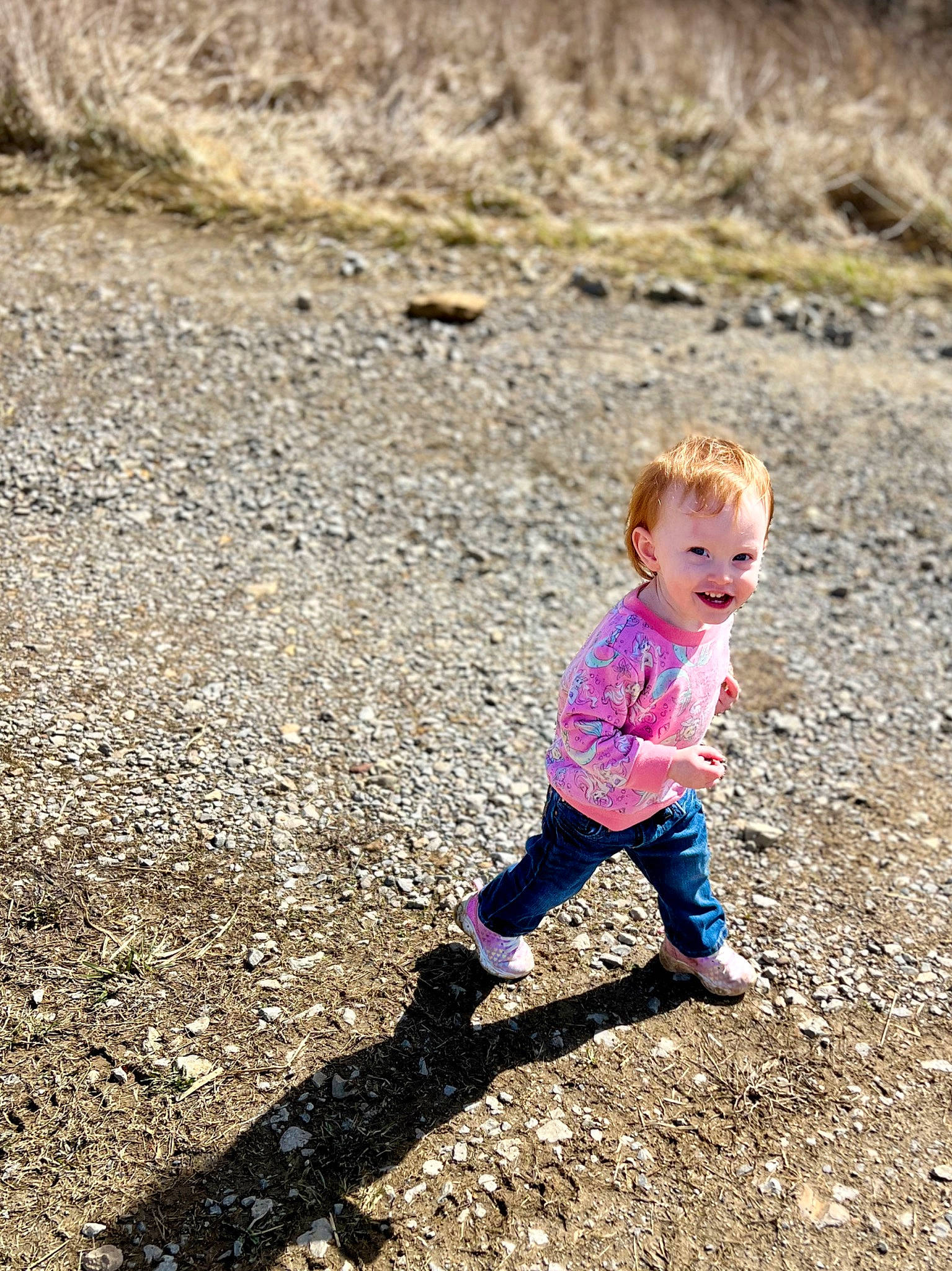 Jemma joined the competition — help win amazing prizes! asphalt, baby_toddler_clothing, child, fun, grass, happy, joy, landscape, leisure, people_in_nature, person, play, road_surface, rock, sand, shadow, sitting, smile, soil, toddler