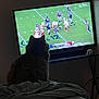 Baby Girl joined the competition — help win amazing prizes! cat, television, football, sports, bed, blanket, indoor, animal, pet, watching, game, team, player, helmet, scoreboard, dark, living_room, feline, silhouette, home