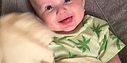 Cole joined the competition — help win amazing prizes! baby, smiling, infant, child, green_clothing, blanket, toy, chair, happy, cute, portrait, indoors, soft_furniture, palm_tree_pattern, holding, waving, playful, young_child, comfort, bright_eyes