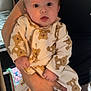 baby, infant, person, child, teddy_bear_pattern, clothing, cute, holding, hand, kitchen, flower, bouquet, utensils, adult, indoor, portrait, expression, face, skin, sleepsuit