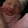 Amelia is registered to the contest to win money with this photo: baby, newborn, smiling, sleepy, hat, flower, pink_clothing, pajamas, hand, closeup, face, infant, cute, cozy, resting, child, portrait, soft_light, peaceful, indoors