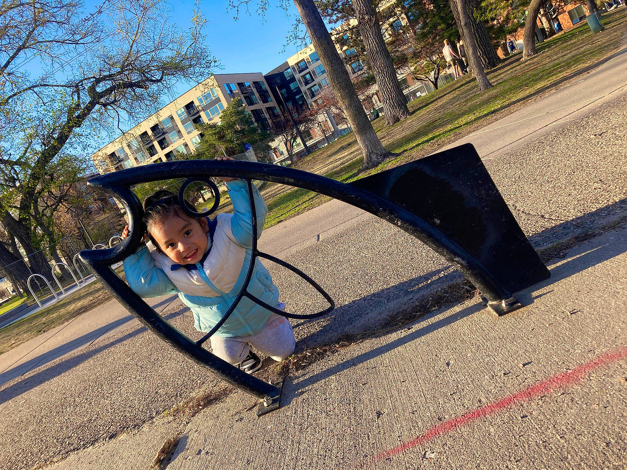 Aubrianna is registered to the contest to win money with this photo: asphalt, building, city, electric_blue, grass, house, joy, leisure, outdoor_play_equipment, person, plant, playground, recreation, road_surface, shade, sidewalk, sky, sunlight, swing, tints_and_shades
