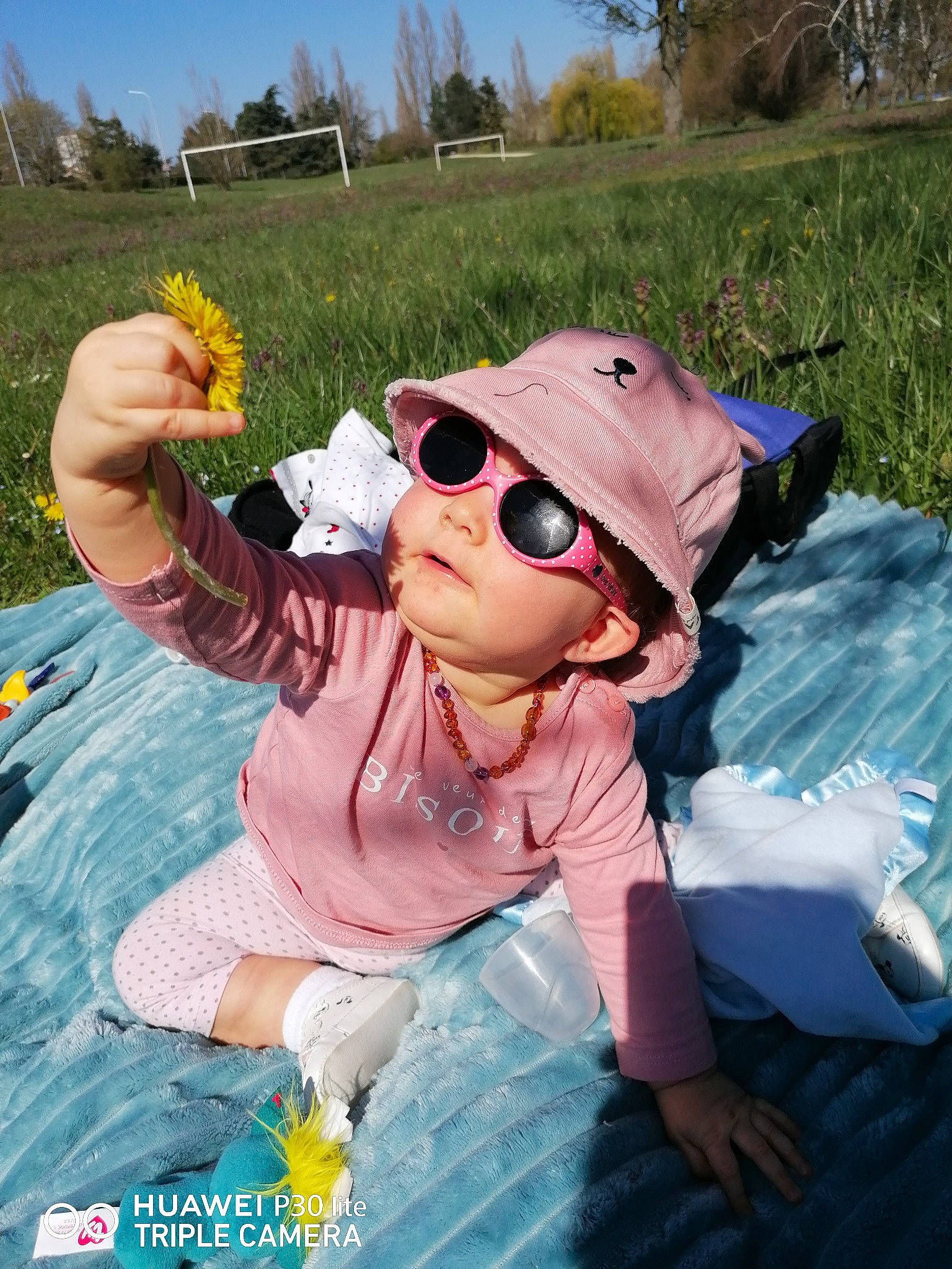 Lou participe au concours pour gagner de l'argent avec cette photo : baseball_cap, cap, eyewear, flower, fun, gesture, goggles, grass, happy, hat, headwear, leisure, people_in_nature, person, pink, plant, sky, sun_hat, sunglasses, tree