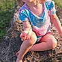 Beverly joined the competition — help win amazing prizes! barefoot, casual, child, colorful_clothing, daylight, face, grass, grass_blade, happy, holding, nature, outdoor, playful, portrait, rock, shirt, sitting, sunlight, toddler, young_child