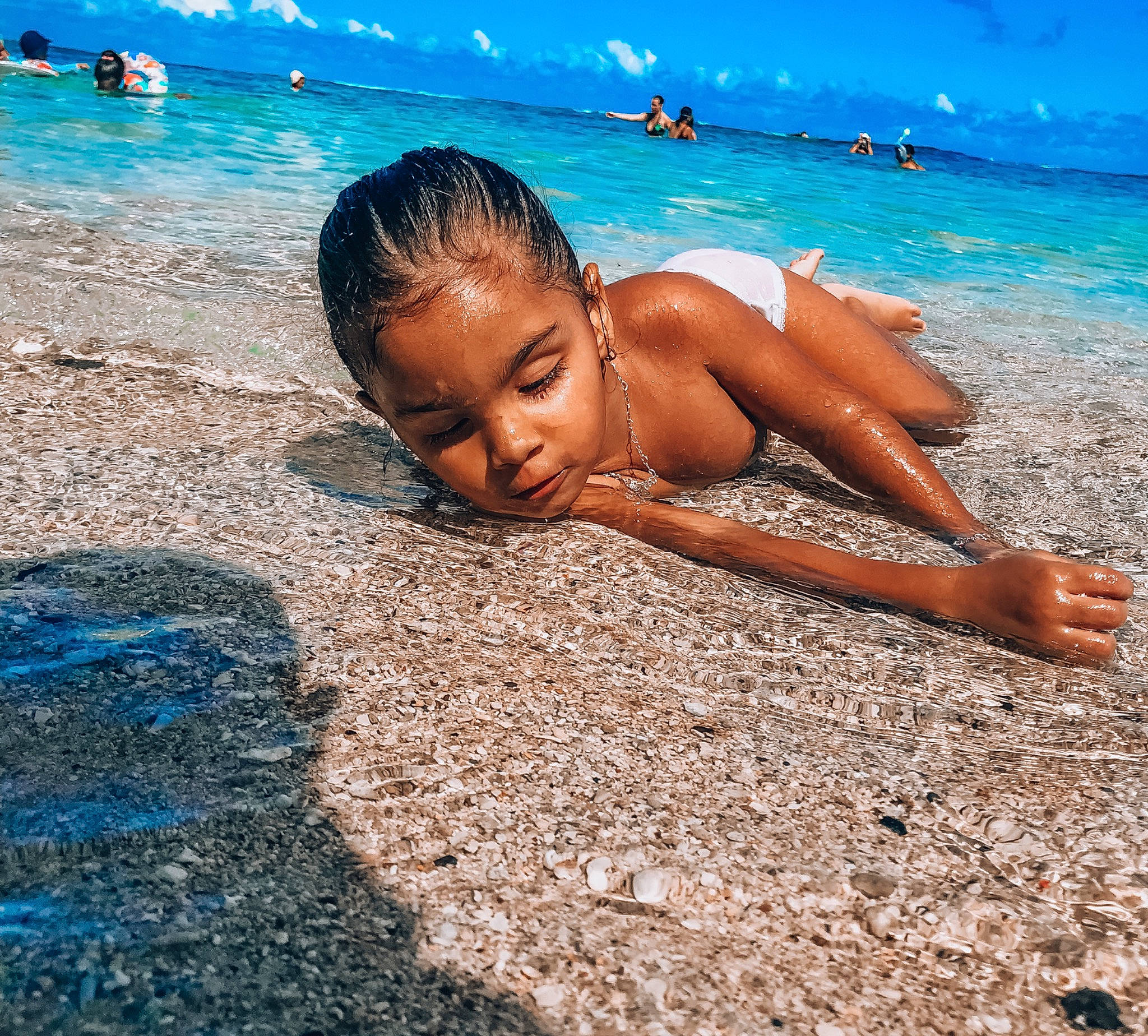 Emy participe au concours pour gagner de l'argent avec cette photo : azure, barechested, barefoot, beach, blue, body_of_water, coastal_and_oceanic_landforms, fun, happy, leisure, people_in_nature, people_on_beach, person, sky, summer, sun_tanning, swimwear, thigh, travel, water
