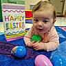 Gianna joined the competition — help win amazing prizes! baby, child, easter, easter_eggs, gift_bag, carpet, colorful, indoor, floor, toy, person, infant, holiday, celebration, pink, blue, green, smiling, cute, playful