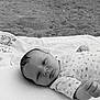 baby, infant, blanket, outdoor, sand, face, portrait, newborn, lying_down, curious, monochrome, nature, soft_texture, peaceful, young_child, closeup, head, expression, relaxation, toddler
