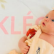 Kléo participe au concours pour gagner de l'argent avec cette photo : baby, infant, headband, blue_eyes, curious, soft_blanket, floral_outfit, pastel_colors, butterfly, leaf_pattern, cute, child, portrait, lying_down, small_hand, skin_texture, indoors, comfortable, adorable, young_child