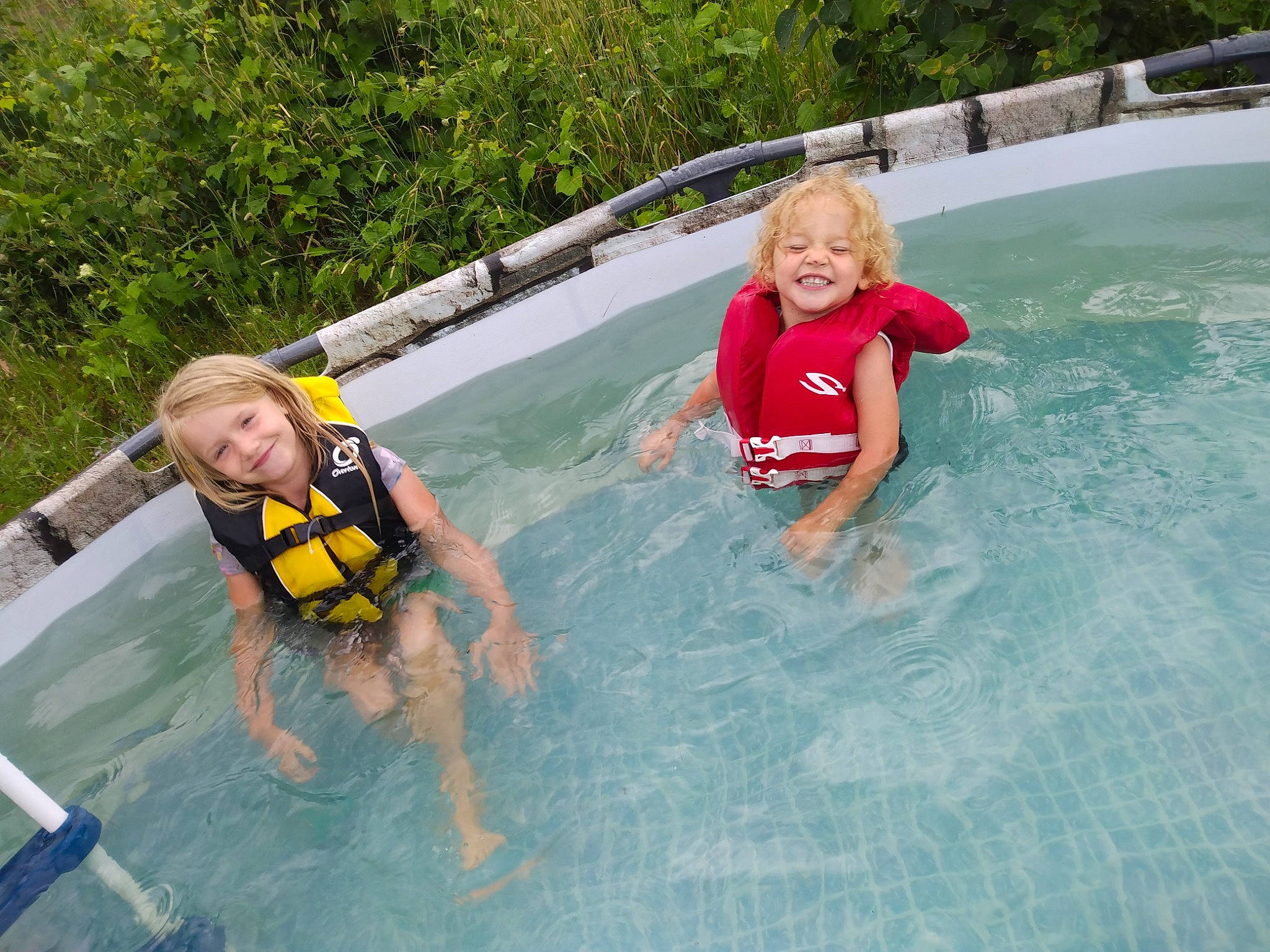 Lexie is registered to the contest to win money with this photo: bathing, child, chute, composite_material, fun, joy, leisure, leisure_centre, lifejacket, nonbuilding_structure, outdoor_recreation, person, personal_protective_equipment, plant, recreation, shorts, smile, swimming_pool, swimwear, toddler