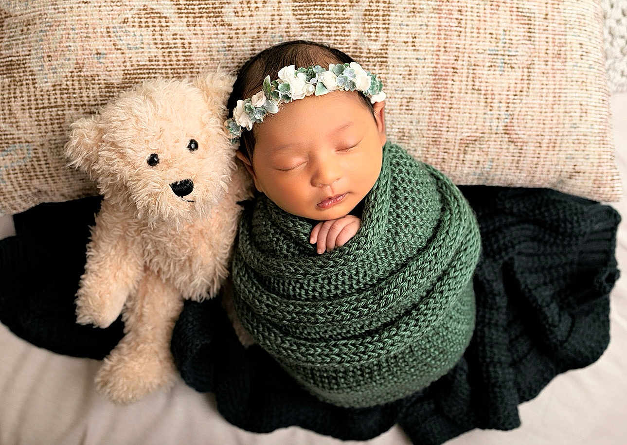 Taashvi joined the competition — help win amazing prizes! newborn, baby, sleeping, teddy_bear, knitted_blanket, floral_headband, pillow, cozy, cute, infant, soft_toy, wrapped, portrait, peaceful, child, indoors, resting, baby_sleep, adorable, comfort