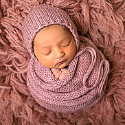 Taashvi is registered to the contest to win money with this photo: newborn, baby, sleeping, knitted_hat, knitted_blanket, pink, soft_texture, wrapped, cozy, portrait, infant, peaceful, cute, child, closeup, studio, warm, tender, snug, resting