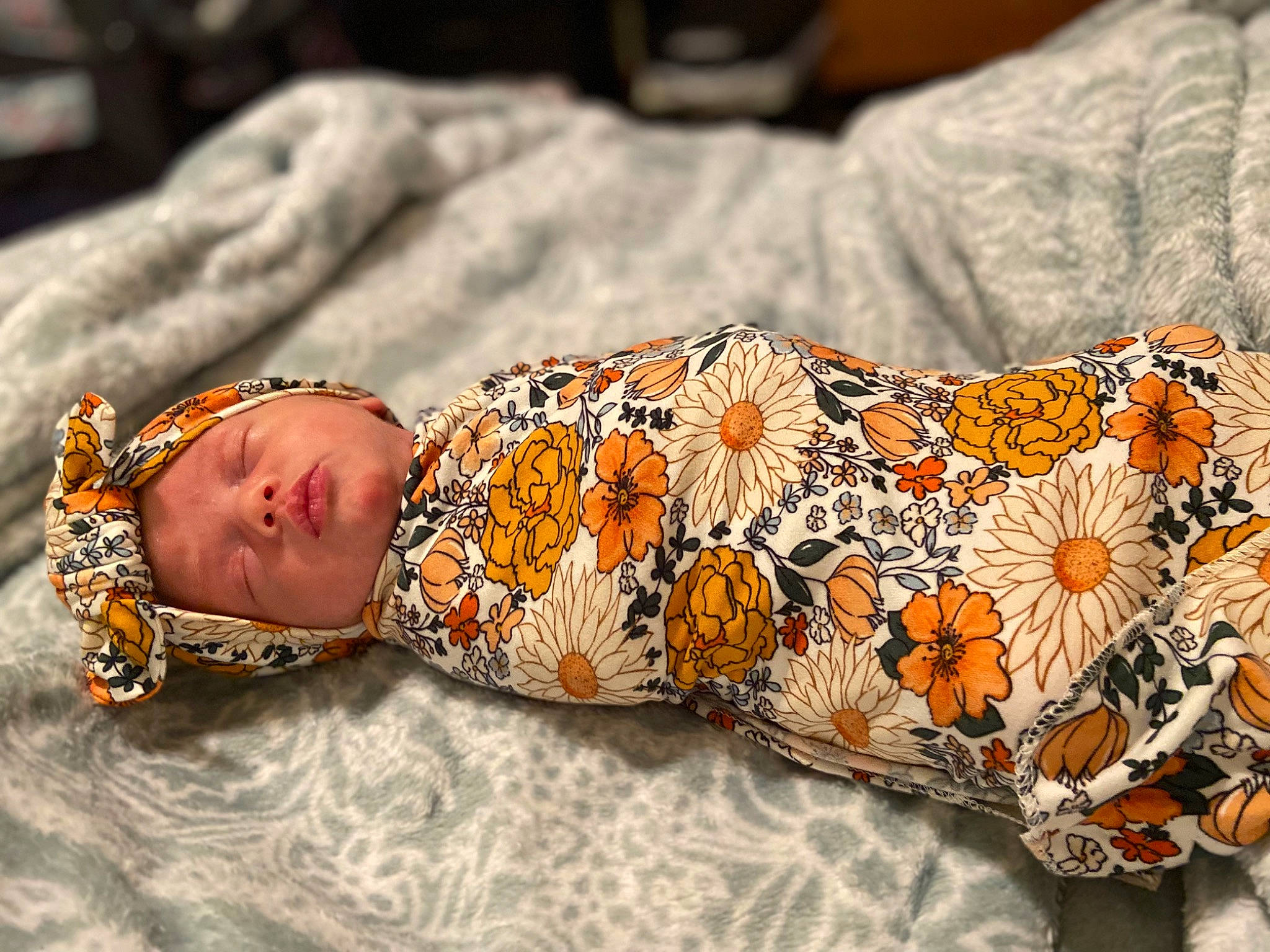 Aphora is registered to the contest to win money with this photo: arm, baby, baby_toddler_clothing, child, comfort, eye, fashion_accessory, hand, head, human_leg, linens, orange, pattern, person, personal_protective_equipment, sitting, sleeve, textile, thigh, toddler