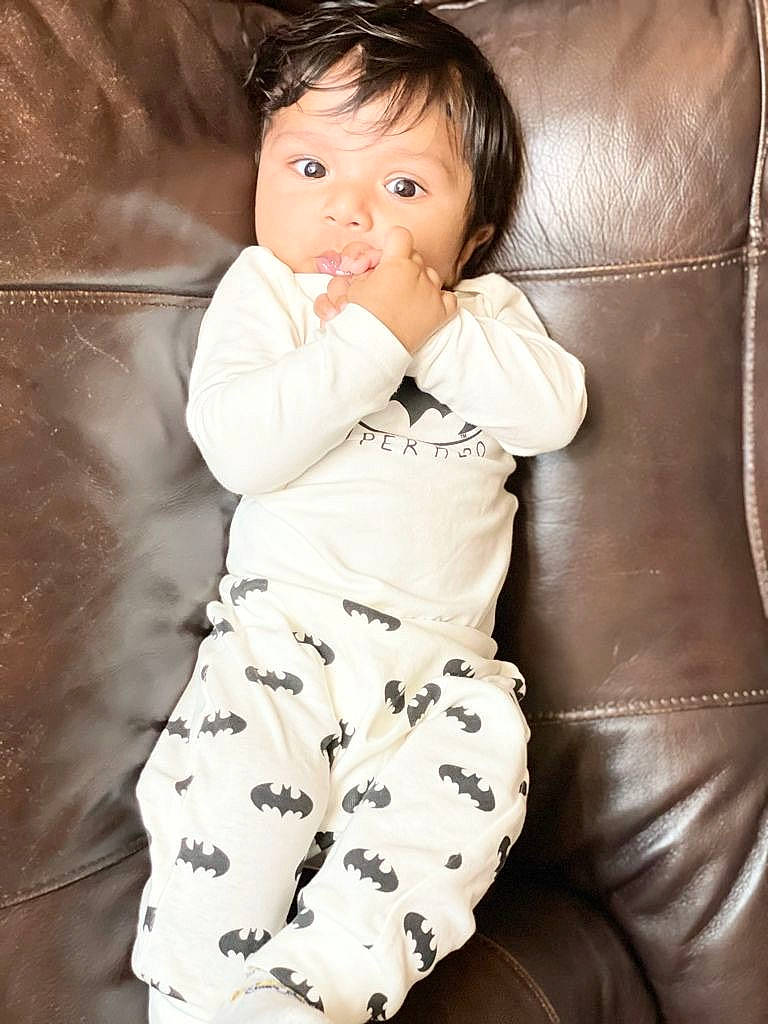 Ishaan is registered to the contest to win money with this photo: baby, baby_toddler_clothing, cheek, child, comfort, elbow, eye, face, flash_photography, hairstyle, happy, head, human_leg, knee, pattern, person, sitting, sleeve, textile, thigh