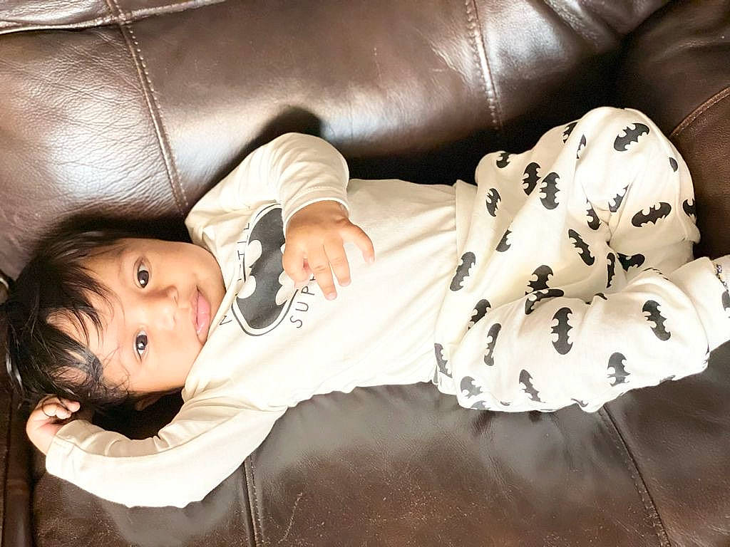 Ishaan is registered to the contest to win money with this photo: baby, baby_toddler_clothing, cheek, child, comfort, couch, flash_photography, fur, human_leg, linens, mouth, person, portrait_photography, room, sitting, skin, sleeve, thigh, toddler, tree