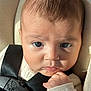 baby, infant, face, eyes, hand, car_seat, seatbelt, clothing, closeup, expression, skin, young_child, portrait, child, cute, newborn, human, safety, indoor, light