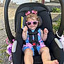baby, car_seat, child, clothing, cute, foot, grass, hair_bows, hand, happy, outdoor, person, pink, playful, rock, seatbelt, smile, summer, sunglasses, toddler