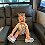 Natalie joined the competition — help win amazing prizes! chair, child, cute, daylight, furniture, hair_bows, happy, indoor, leather, nature, person, shirt, shoes, shorts, sitting, smiling, socks, toddler, vehicle, window