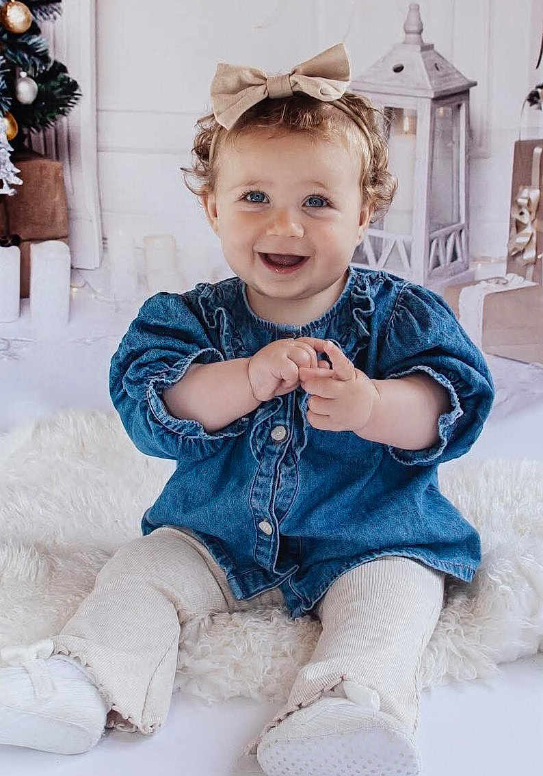 Indie joined the competition — help win amazing prizes! baby, child, smiling, denim, bow, blue_eyes, white_rug, holiday, lantern, wrapped_gifts, curly_hair, sitting, happy, indoors, cute, portrait, clothing, footwear, decor, infant