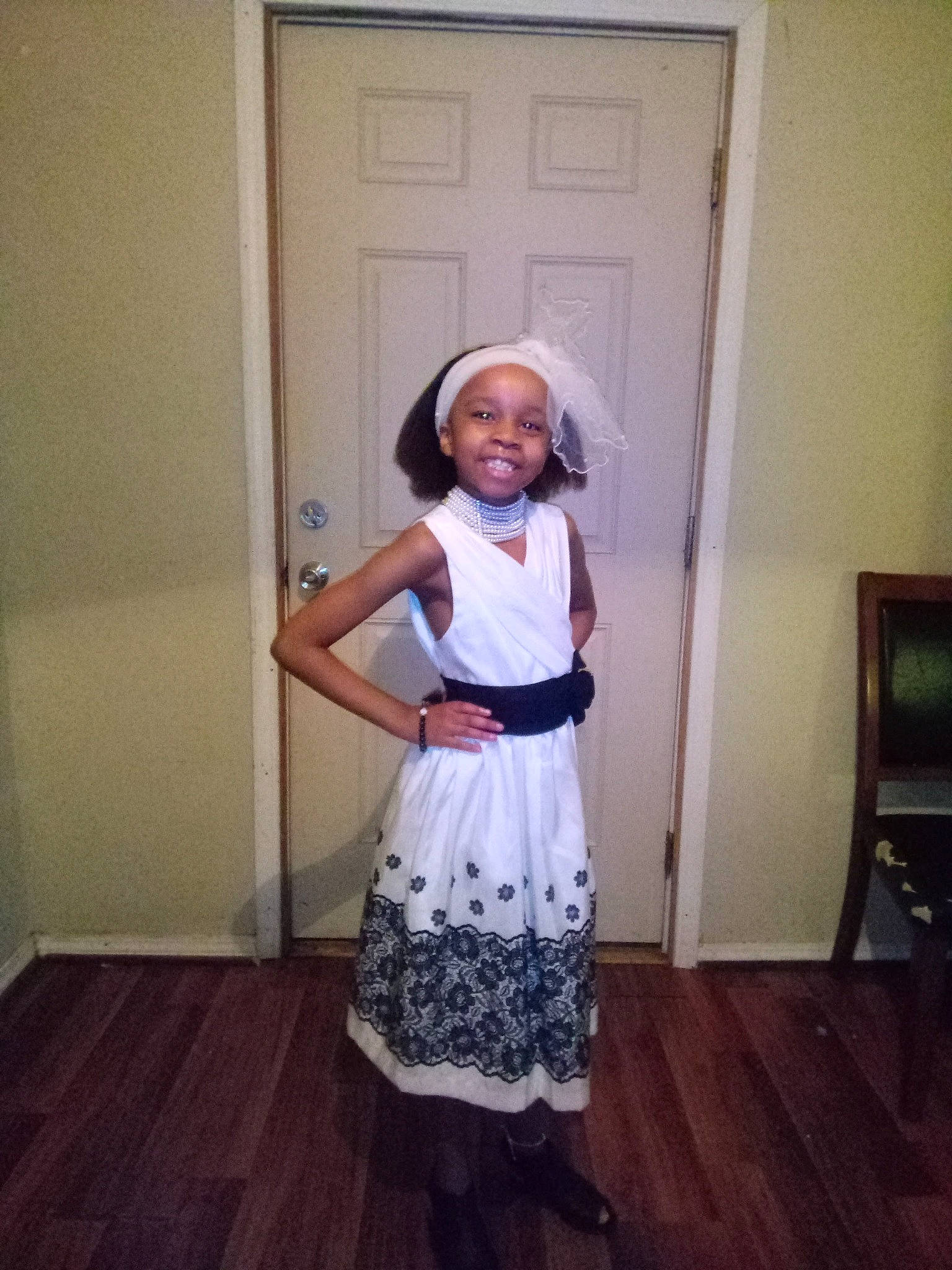 Pamela joined the competition — help win amazing prizes! costume, day_dress, door, dress, eyewear, fashion_design, flooring, formal_wear, hat, joy, knee, pattern, person, purple, shoulder, sleeve, smile, sunglasses, toddler, trunk