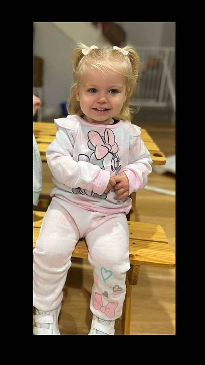 Poppie is registered to the contest to win money with this photo: baby, baby_toddler_clothing, child, face, flooring, formal_wear, fun, hair, happy, joy, pajamas, pattern, peach, person, portrait_photography, room, sitting, sleeve, smile, sportswear