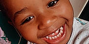 Kayden is registered to the contest to win money with this photo: child, toddler, smiling, face, closeup, onesie, clothing, indoor, happy, cute, person, skin, hair, eyes, teeth, pink, green, pattern, baby, portrait