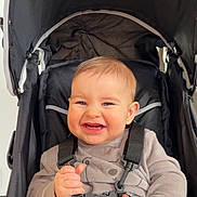 Marius participe au concours pour gagner de l'argent avec cette photo : baby, infant, stroller, canopy, harness, buckle, smile, teeth, hands, clothing, onesie, seat, portrait, closeup, happy, straps, baby_face, young_child, indoor, cozy